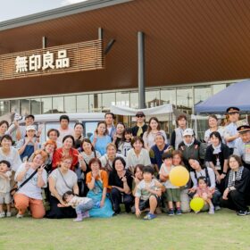 無印良品 東武動物公園駅前店前で撮影された、出店者・関係者による集合写真。約40名が笑顔でカメラに向かってポーズ。