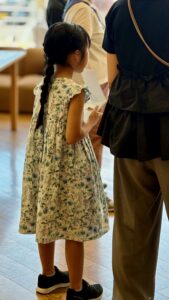 ワンピース姿の女の子がメモを取りながら参加している様子。子どもが主体的に学ぶ「イヌの学び舎」の雰囲気が伝わる。