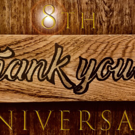木目調の背景に、中央の木板へ「Thank you!!」と手書き風の黒字が刻まれている。上部には「8th」、下部には「ANNIVERSARY」と金色の文字が配置され、One for Dog の8周年を祝うデザインになっている。