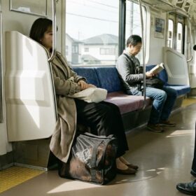 犬用キャリーに入った愛犬と電車で移動する様子