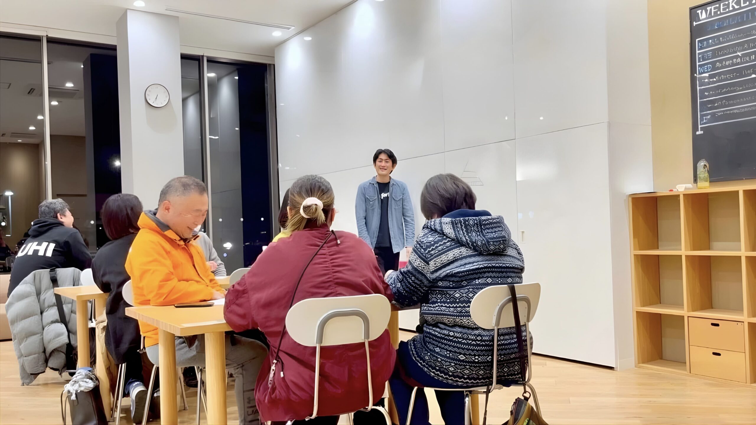 室内会場でテーブルを囲み、少人数の参加者に向けて講師が犬との暮らしについて講義を行っている様子