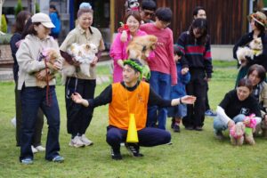 新しい村ドッグイベントで参加者と愛犬が集まりゲーム前に輪になる様子