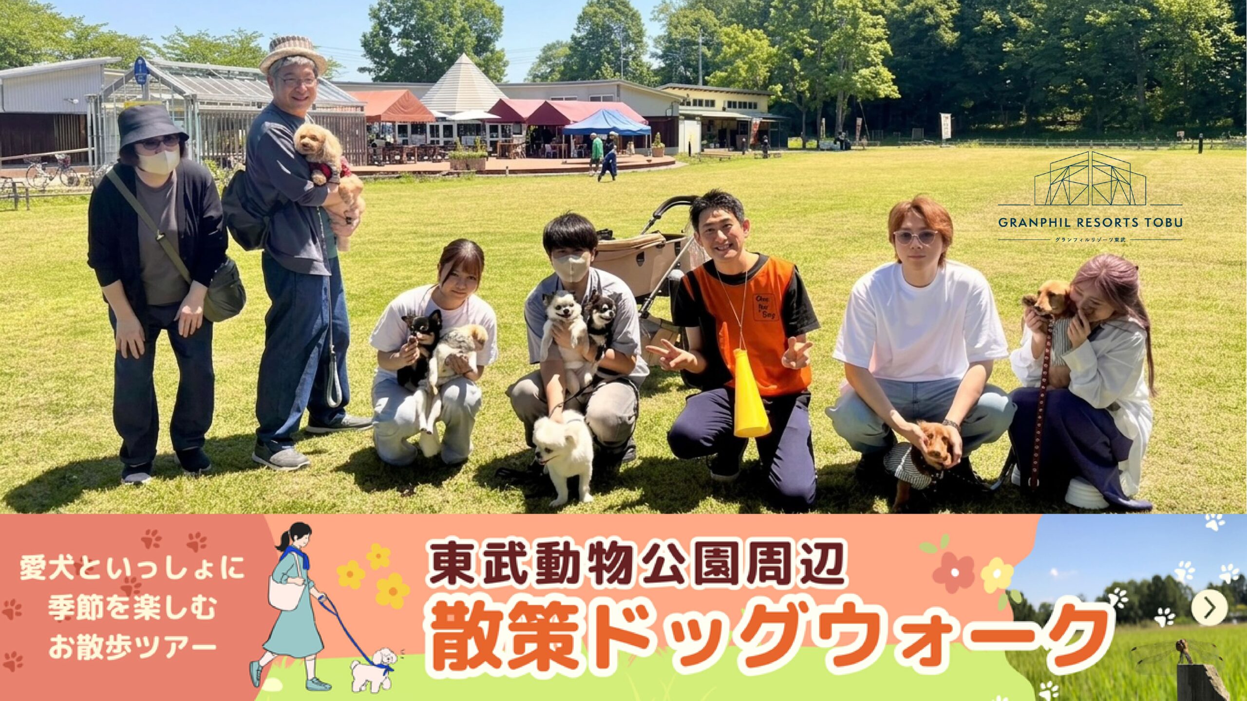 東武動物公園周辺で開催された「散策ドッグウォーク」の集合写真。愛犬家のご家族とスタッフが芝生広場に集まり、和やかな雰囲気で記念撮影をしている様子。