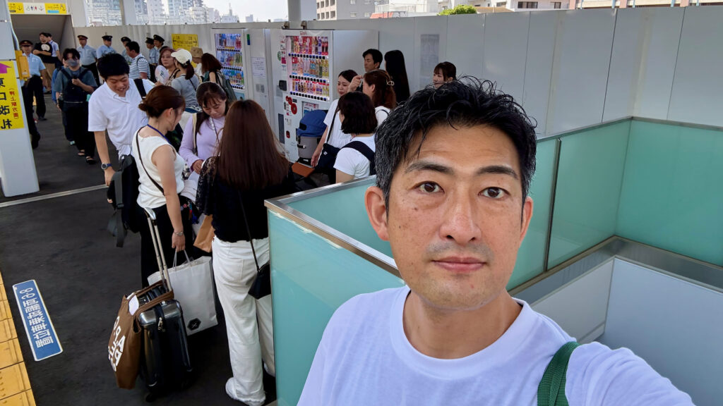 駅のホームに集合したTOBU Doggy Doggy Trainの参加者と、手前で撮影する齋藤