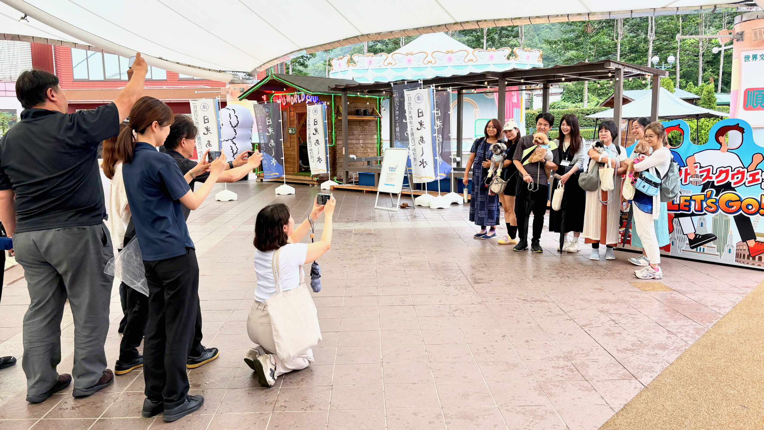 東武ワールドスクウェアで、愛犬を抱いて記念撮影するTOBU Doggy Doggy Trainの参加者たち