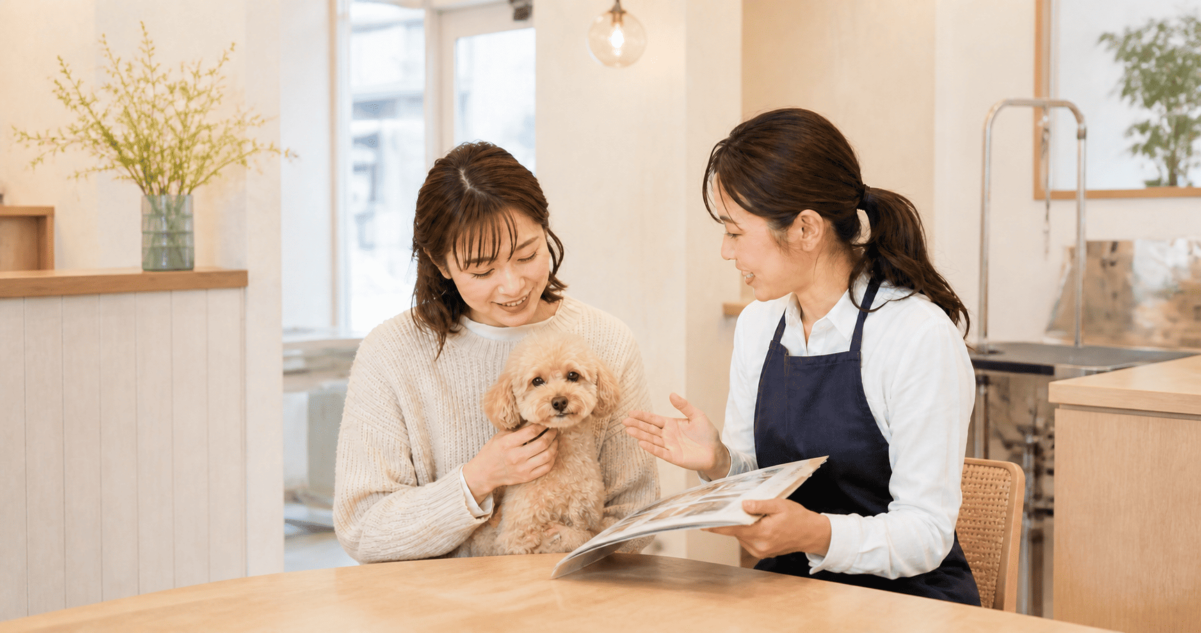 トリミングサロンで愛犬のケアについて飼い主さんへ説明するトリマー